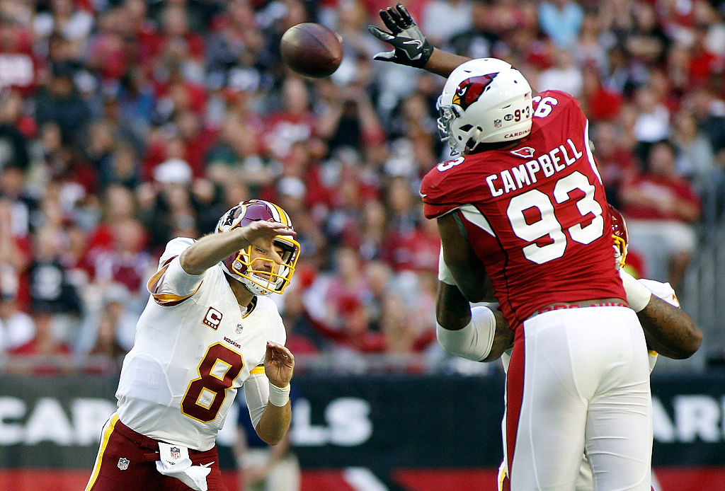 Calais Campbell of the Arizona Cardinals leaps to block the pass of quarterback Kirk Cousins of the Washington Redskins