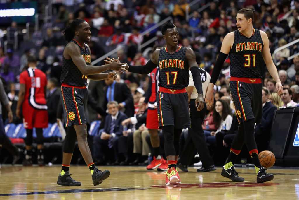 Taurean Prince, Dennis Schroder, and Mike Muscala of the Atlanta Hawks walk off the floor during a timeout.