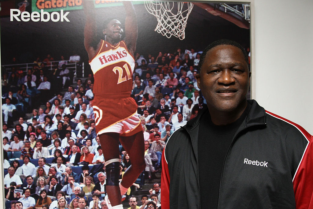 Former NBA player and Hall of Famer Dominique Wilkins poses next to his own poster.