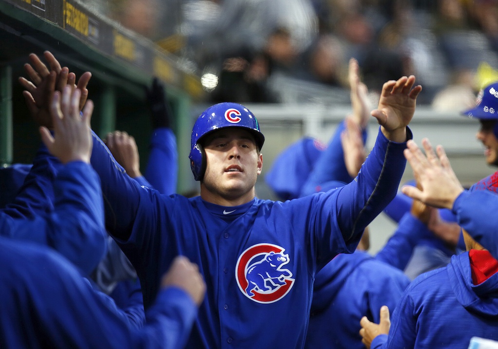 Anthony Rizzo high fives his teammates in the dugout.