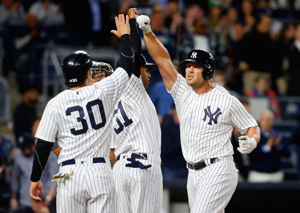 Matt Holliday of the New York Yankees celebrates his third-inning, three-run home run against the Chicago White Sox with teammates Aaron Hicks and Pete Kozma.