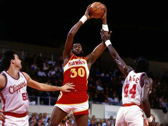 Tree Rollins tries to protect the ball.