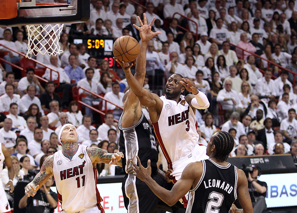 Dwyane Wade pushes past defenders for a layup.
