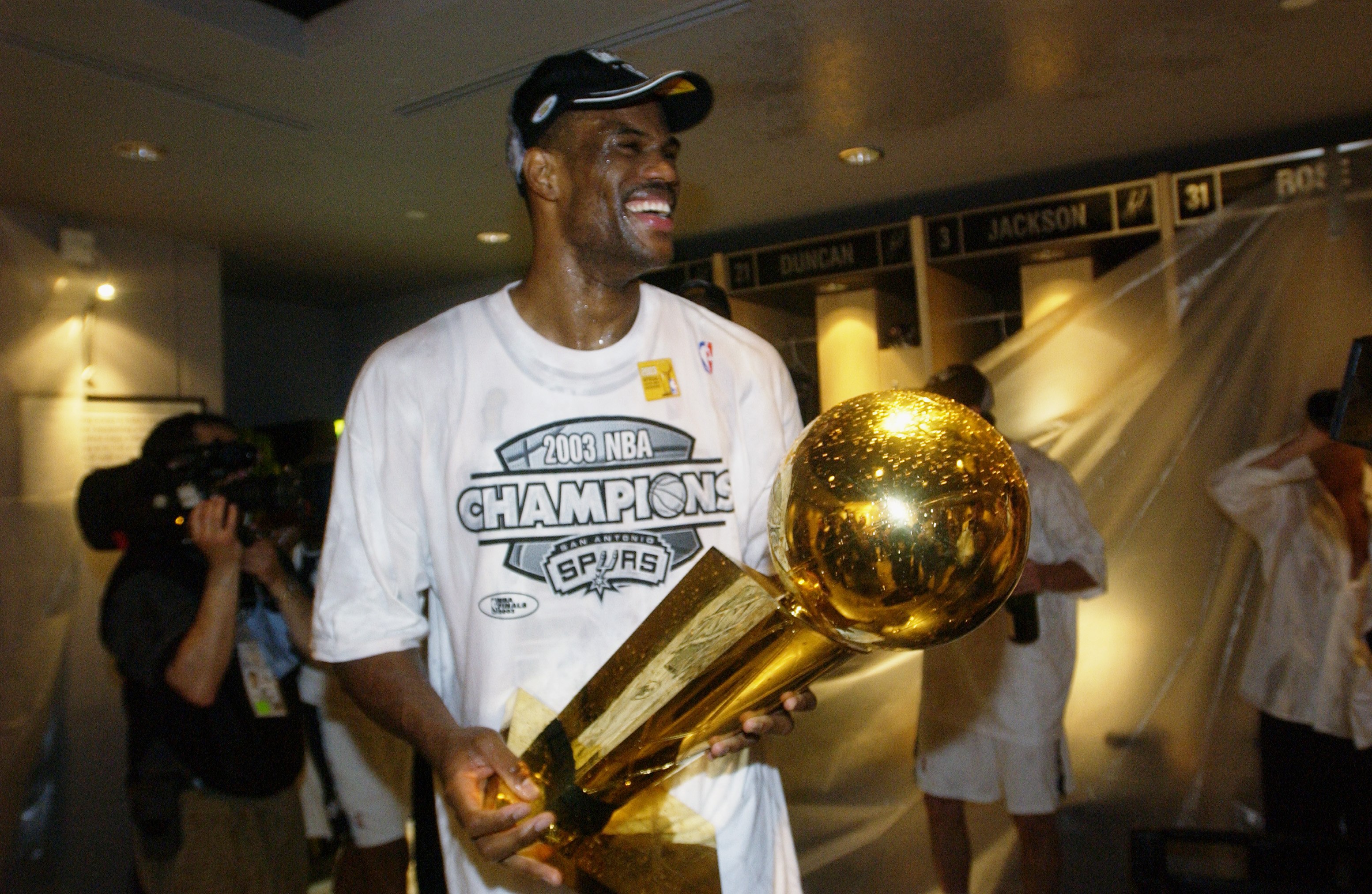 David Robinson holds the trophy in the locker room.
