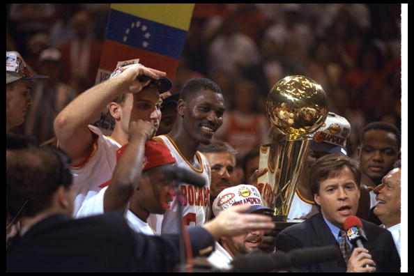Hakeem Olajuwon gets ready to hoist the trophy.