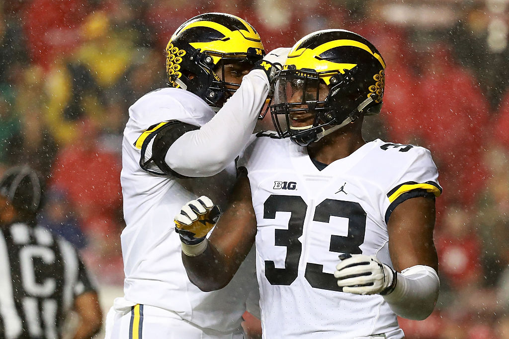 Taco Charlton of the Michigan Wolverines celebrates with his teammate.
