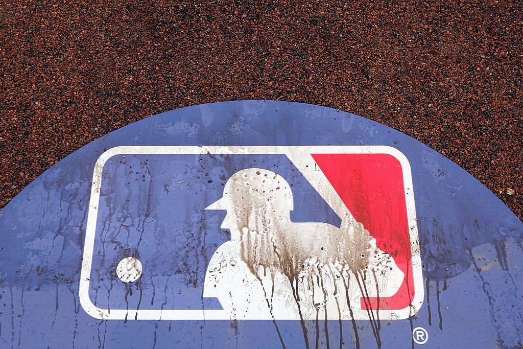 Dirt covers an MLB logo on an infield.