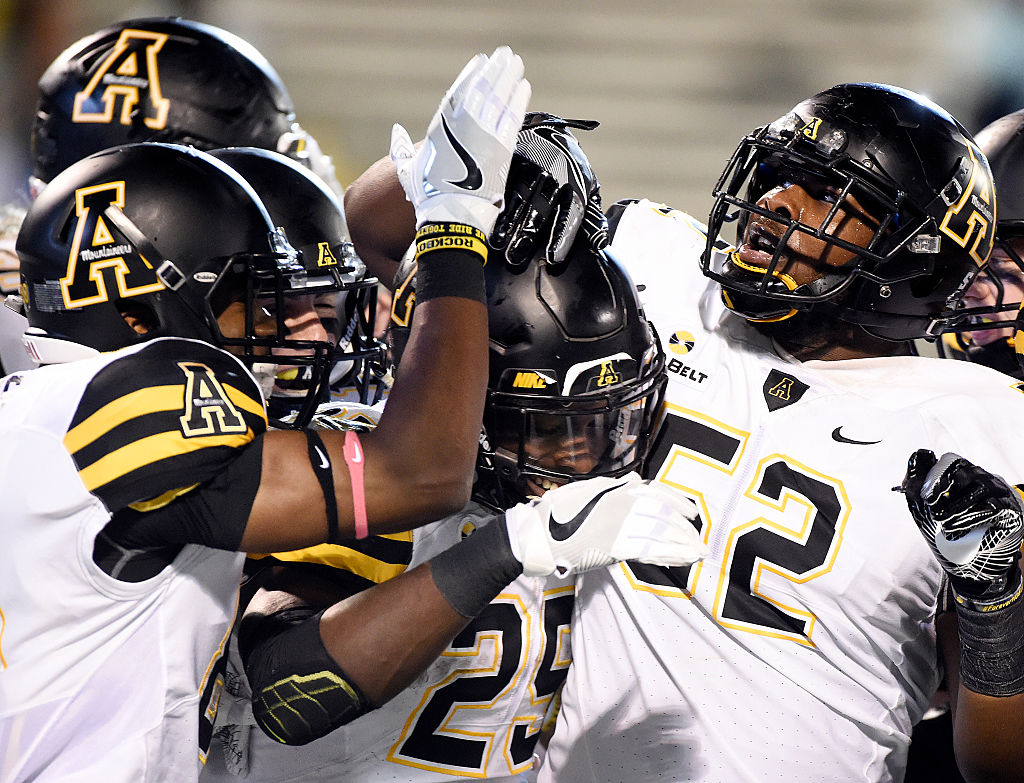 Running back Jalin Moore of the Appalachian State Mountaineers is congratulated by teammates after scoring a touchdown.