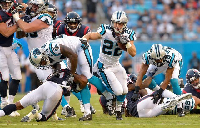 Christian McCaffrey carries the football. Christian McCaffrey #22 runs through the hole.