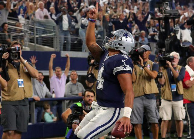 Dak Prescott runs for a touchdown. Dak Prescott points to the sky after rushing for a touchdown.