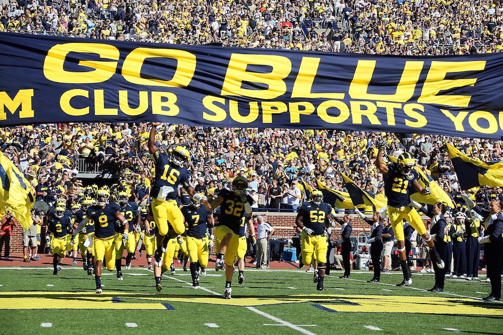 Denard Robinson of the University of Michigan Wolverines leads his team to the field.