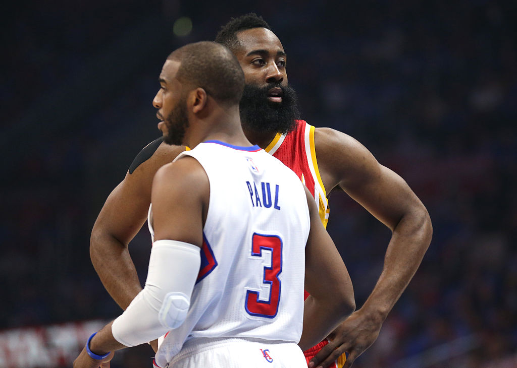 Chris paul and James Harden talk on the court.