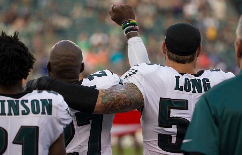Malcolm Jenkins #27 of the Philadelphia Eagles holds his fist in the air while Chris Long #56 of the Philadelphia Eagles puts his arm around him during the national anthem.