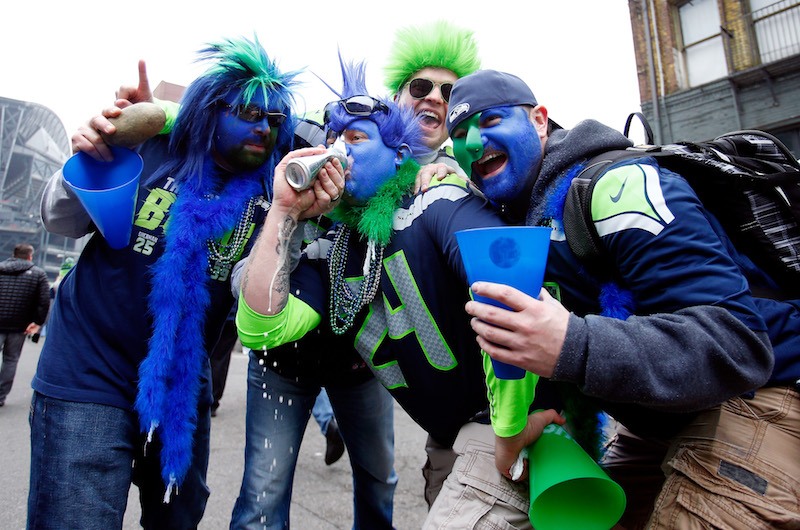 Seattle Seahawks fans drink a beer before a game.