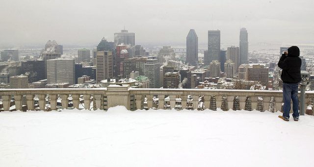 A man takes a picture of the Montreal skyline from the top of Mount Royal A man takes a picture of the Montreal skyline from the top of Mount Royal