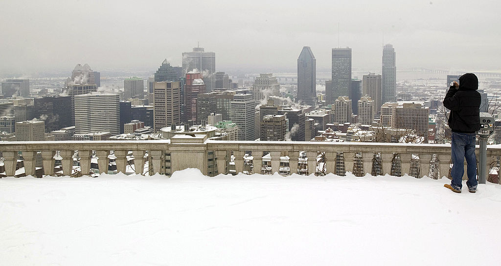 A man takes a picture of the Montreal skyline from the top of Mount Royal A man takes a picture of the Montreal skyline from the top of Mount Royal