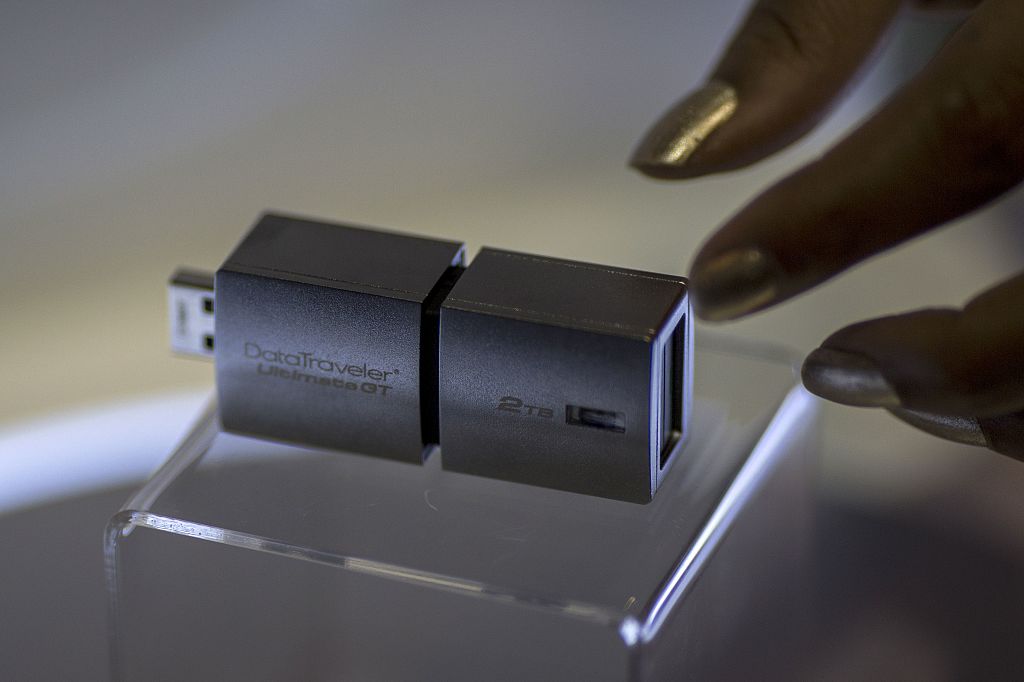 a hand reaches for a USB drive on display