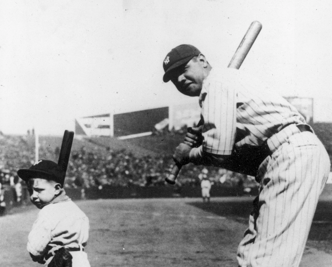Babe Ruth playing baseball with a small child. 