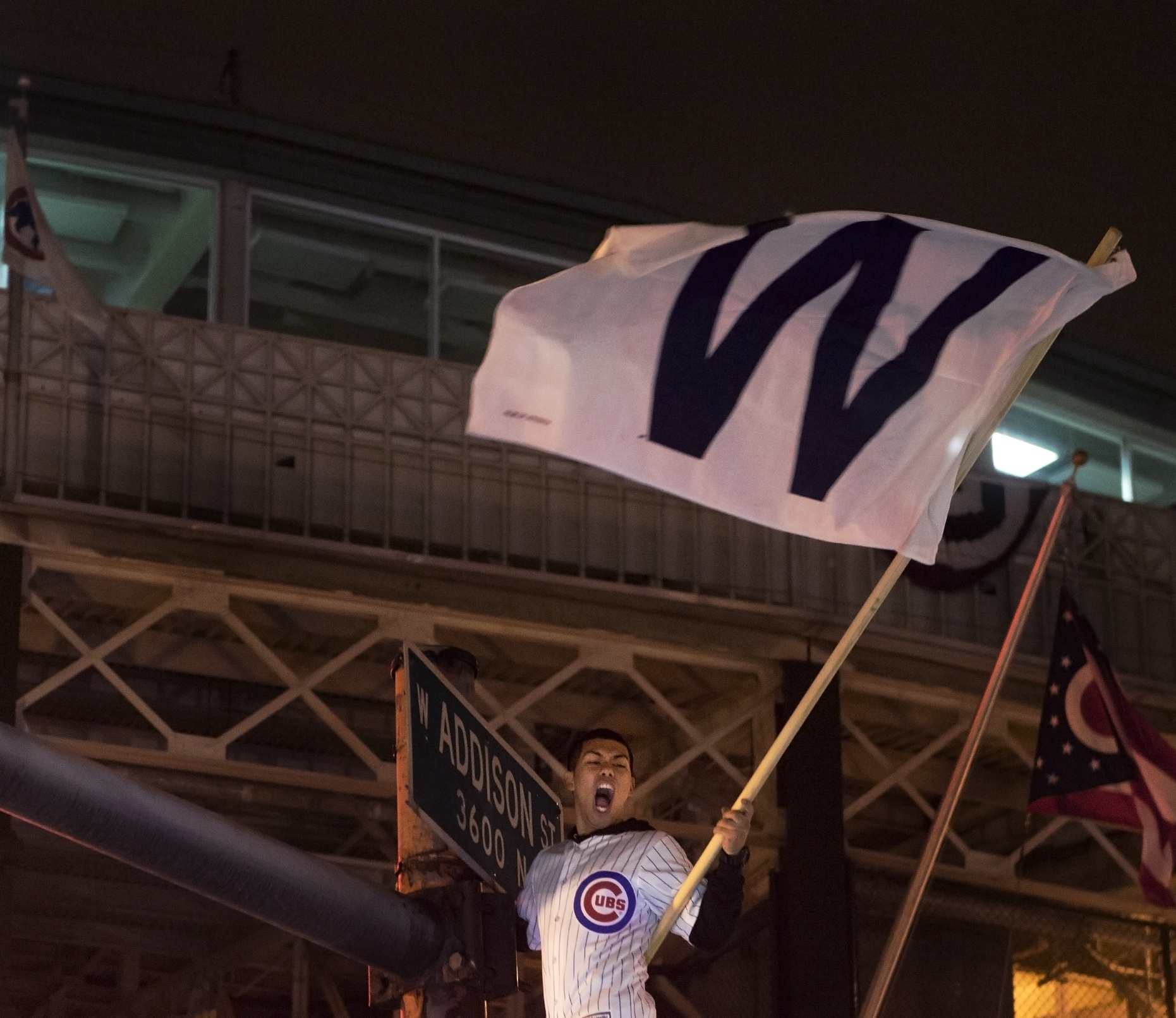 a fan waves a W flag outside wrigley field