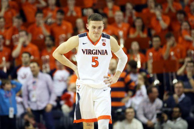 Kylie Guy standing on a basketball court with his hands on his hips. Kylie Guy standing on a basketball court with his hands on his hips.