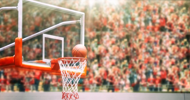 A ball going through a basketball hoop. 