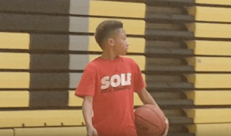 Jordan Lowery holding a basketball inside a gym. 