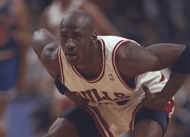 Michael Jordan bending on the basketball court. 
