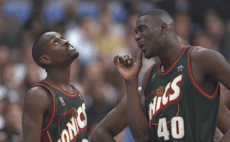 Two basketball players from the Sonics standing next to each other. 