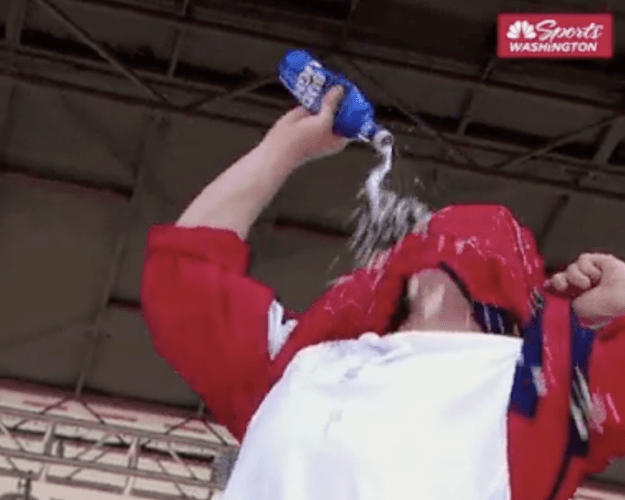 A fan drinking beer through his shirt. A fan drinking beer through his shirt.