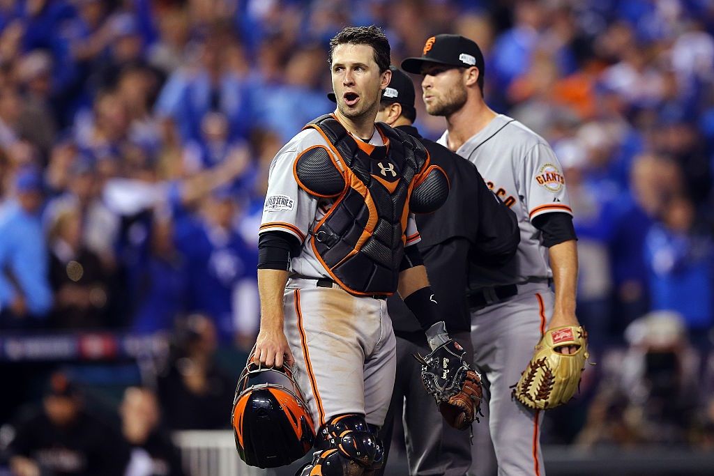 Buster Posey tries to keep Hunter Strickland from fighting with Salvador Perez of the Kansas City Royals