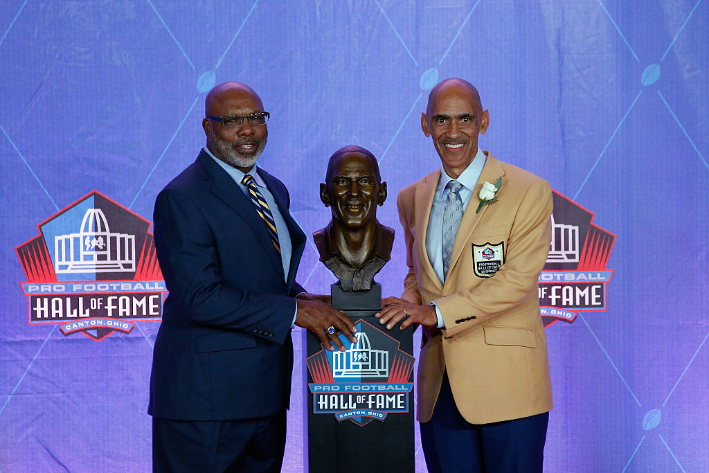 Tony Dungy (R), former NFL player and head coach, poses next to his bronze bust with friend and former NFL player, presenter Donnie Shell (L)