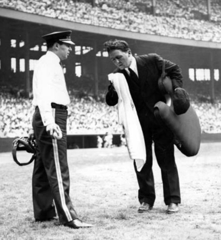 July 5, 1948-Suited up home plate ump Eddie Hurley does his best to stay cool on