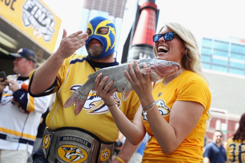 A Nashville Predators fan holds a catfish