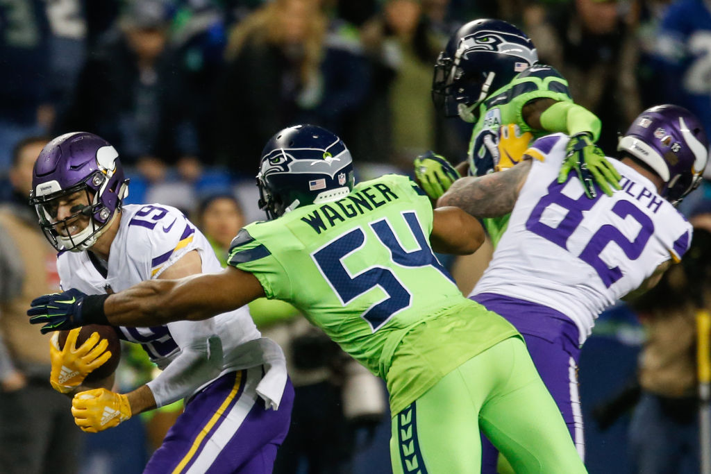 Bobby Wagner #54 of the Seattle Seahawks tackles Adam Thielen