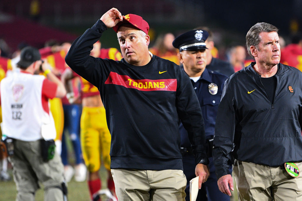 USC head honcho Clay Helton (center) is one of the college football coaches on the hot seat in 2019.