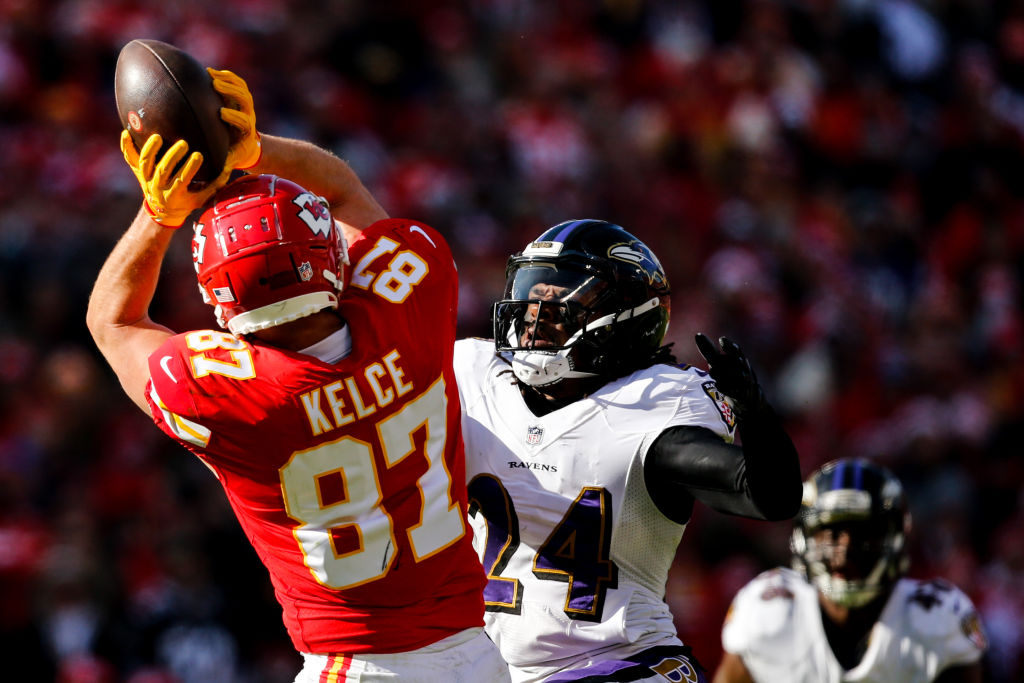 Travis Kelce #87 of the Kansas City Chiefs hauls in a pass over the coverage of Brandon Carr