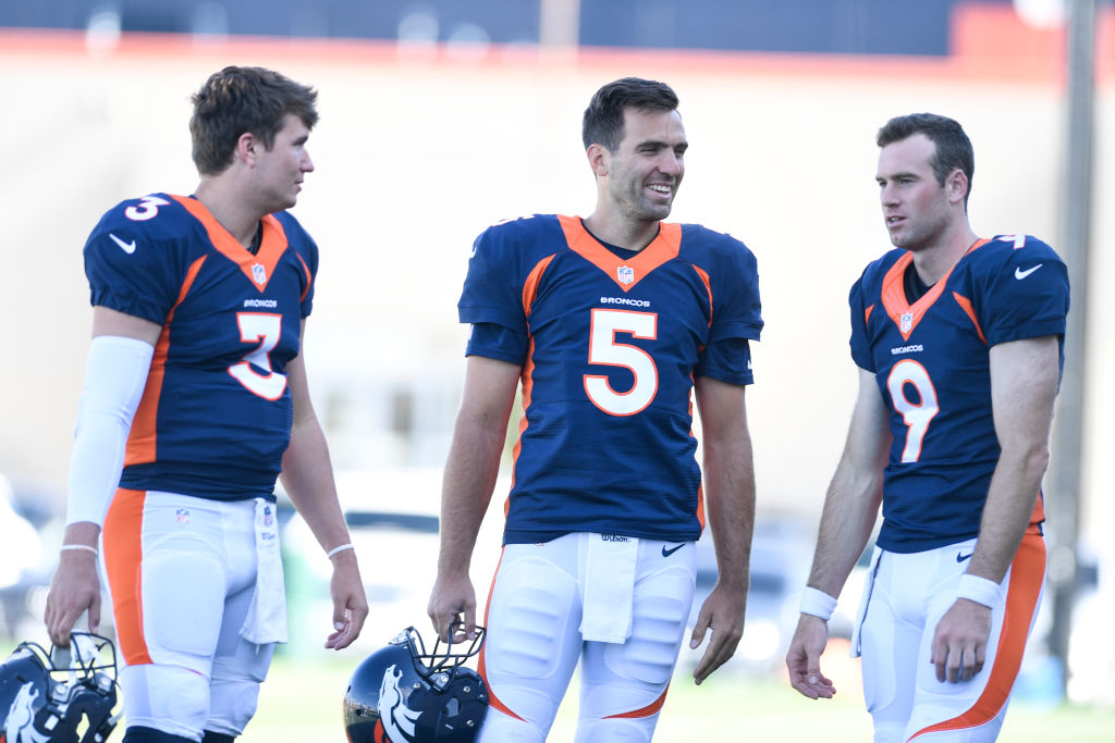 Joe Flacco (5) of the Denver Broncos jokes with Drew Lock (3) and Kevin Hogan (9) during Denver Broncos training camp