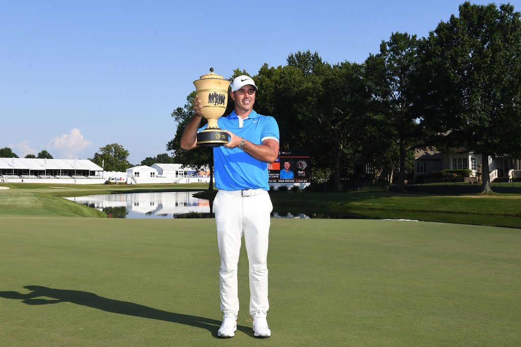 Brooks Koepka poses with the trophy