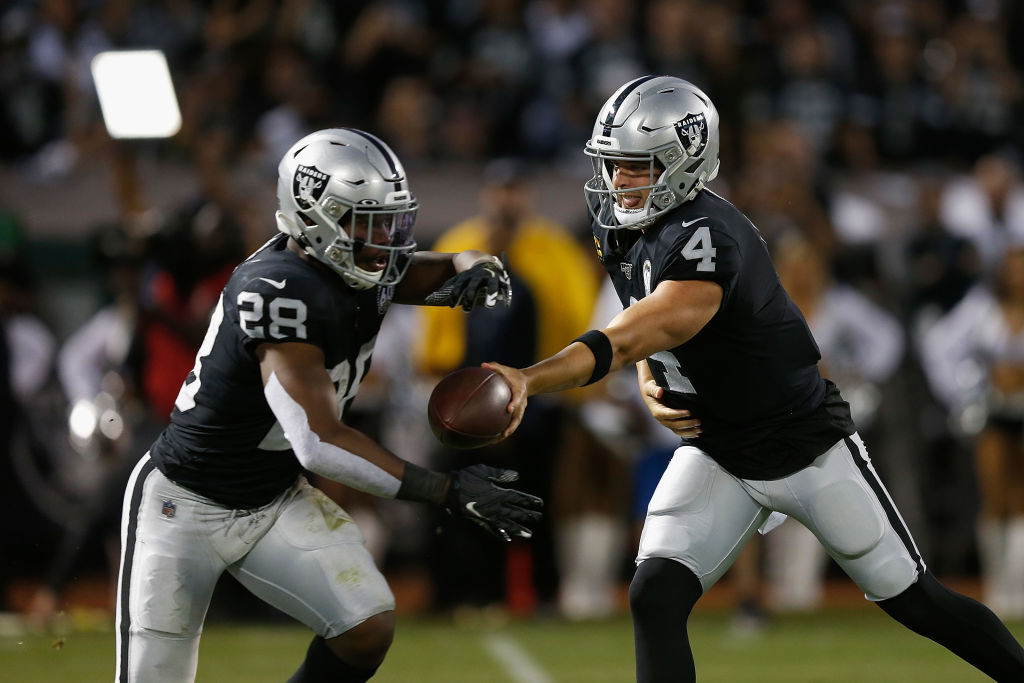 Quarterback Derek Carr #4 of the Oakland Raiders hands the ball off to running back Josh Jacobs #28
