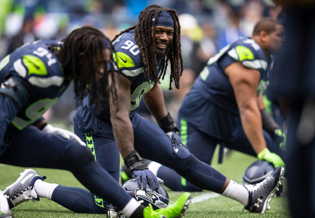 Jadeveon Clowney of the Seattle Seahawks and Ezekiel Ansah stretch before a game