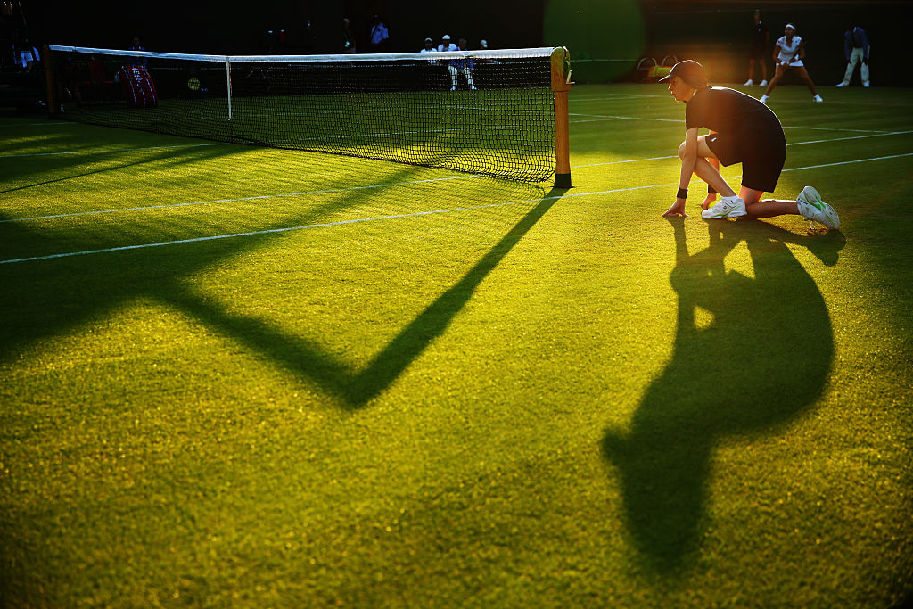 A tennis ball boy waiting on the sidelines at Wimbledon