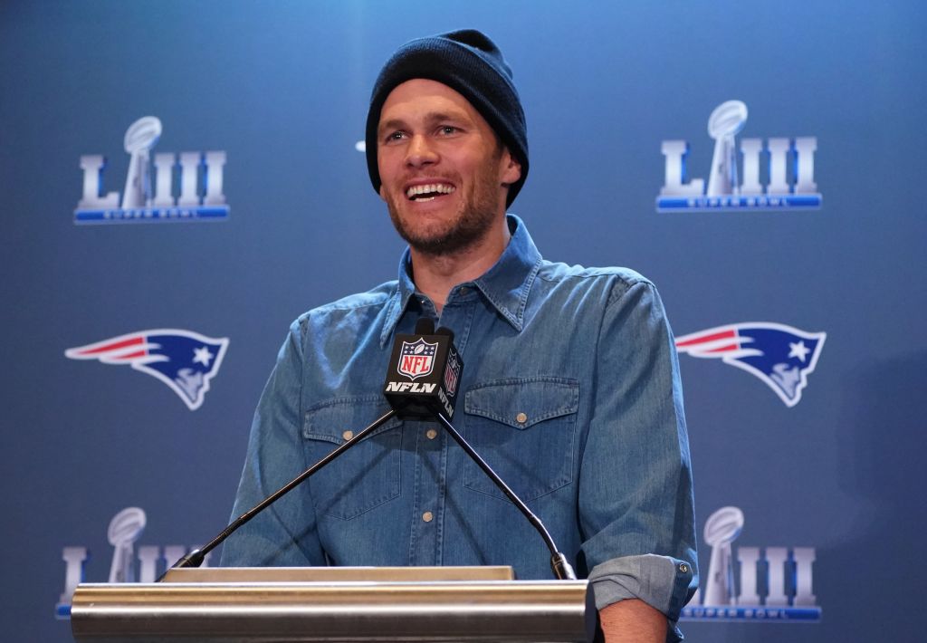 Tom Brady stands at a microphone during a press conference
