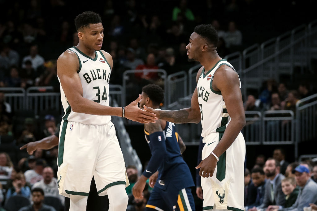 Giannis Antetokounmpo high fives a teammate during a Bucks game