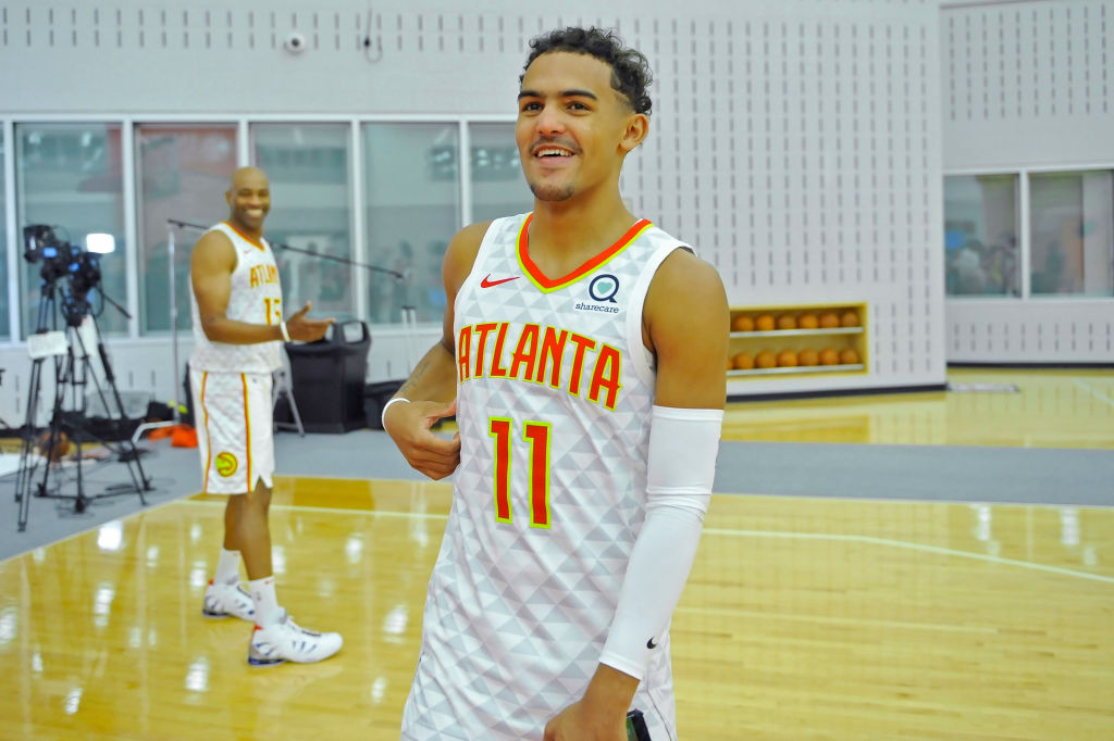 Atlanta Hawks guard Trae Young smiles as he walks toward reporters