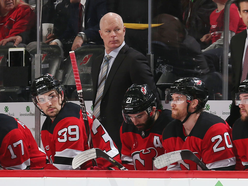 John Hynes coaches the New Jersey Devils in NHL action.