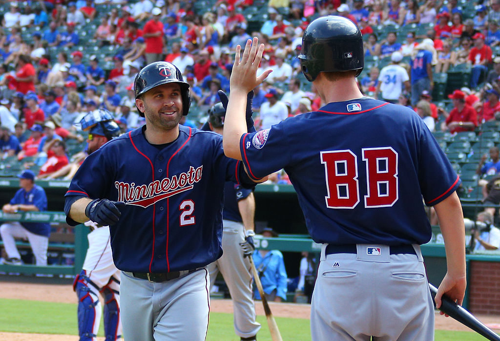 An MLB bat boy gives a player a high five after a home run.