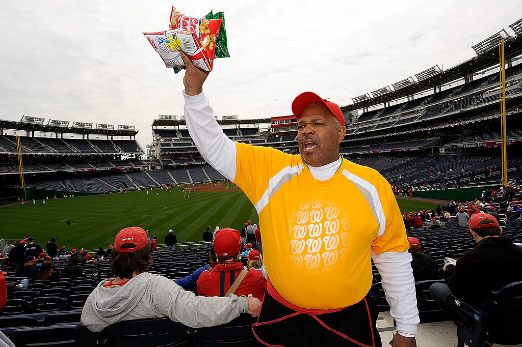 An MLB food vendor holds some bags of Cracker Jacks