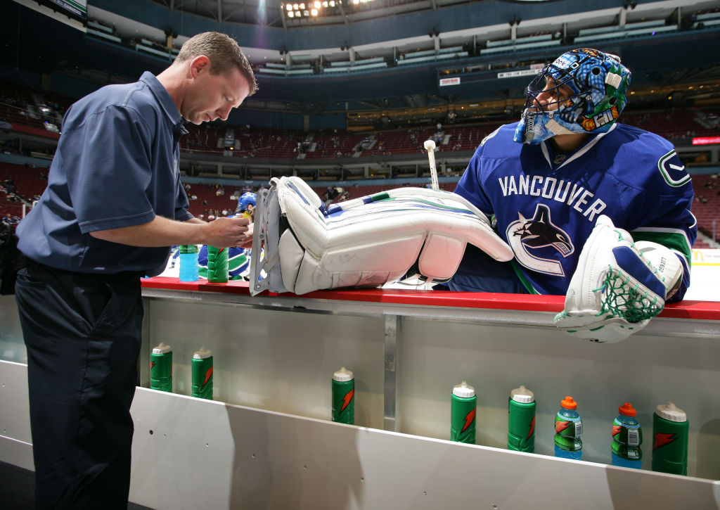 An NHL equipment manager sharpens the skates of a player.