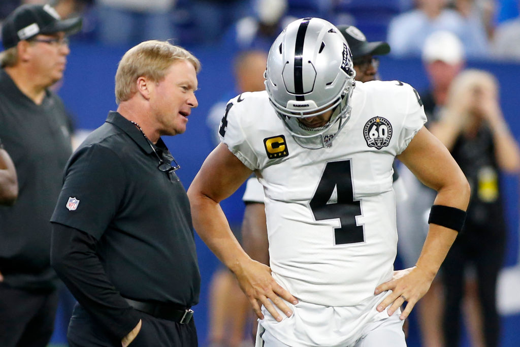 Head coach Jon Gruden of the Oakland Raiders talks with Derek Carr