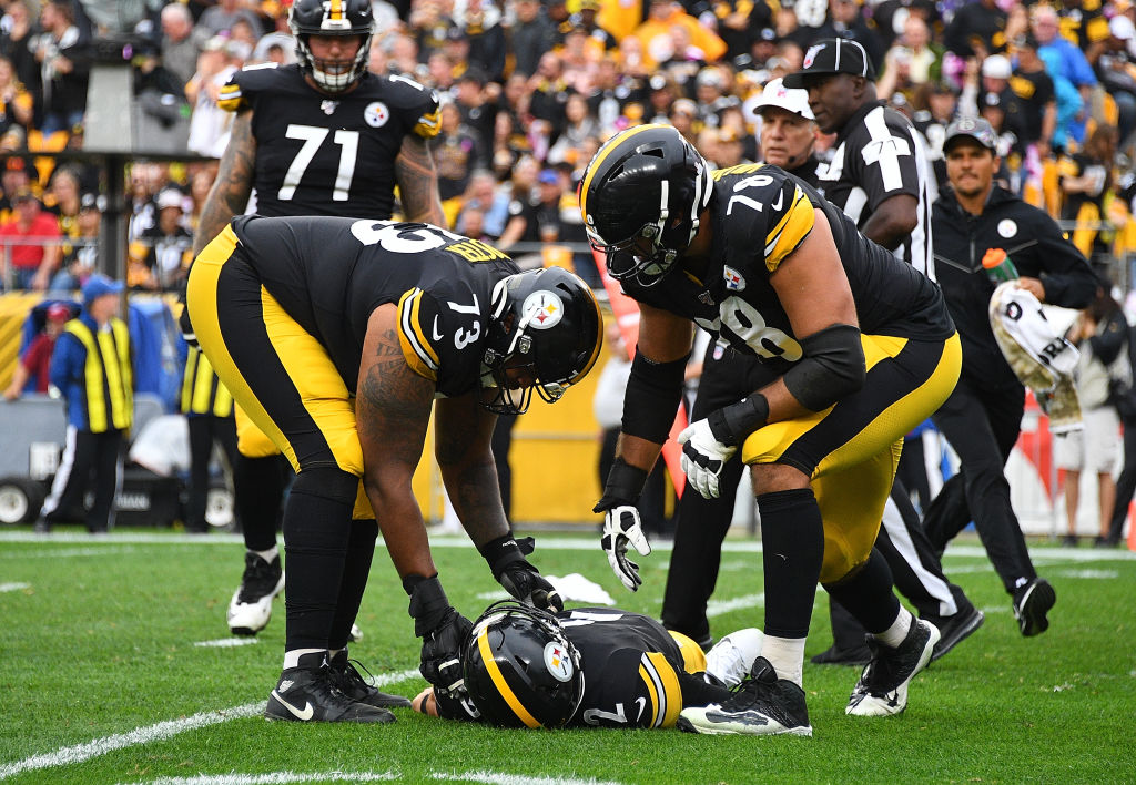 Ramon Foster and Alejandro Villanueva check on Mason Rudolph of the Pittsburgh Steelers after he is injured